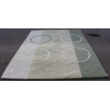 A modern thick pile rug decorated with three cream circles and a green circle against three light-