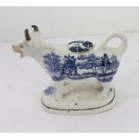 A 19th century blue and white Staffordshire cow creamer: Willow pattern transfer ware, black lined