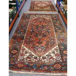 Two similar rugs: 1. a North West Persian hand-knotted rug with central cobalt-blue medallion