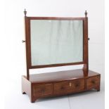 An early 19th century bow-fronted mahogany toilet mirror: rectangular boxwood-strung plate flanked