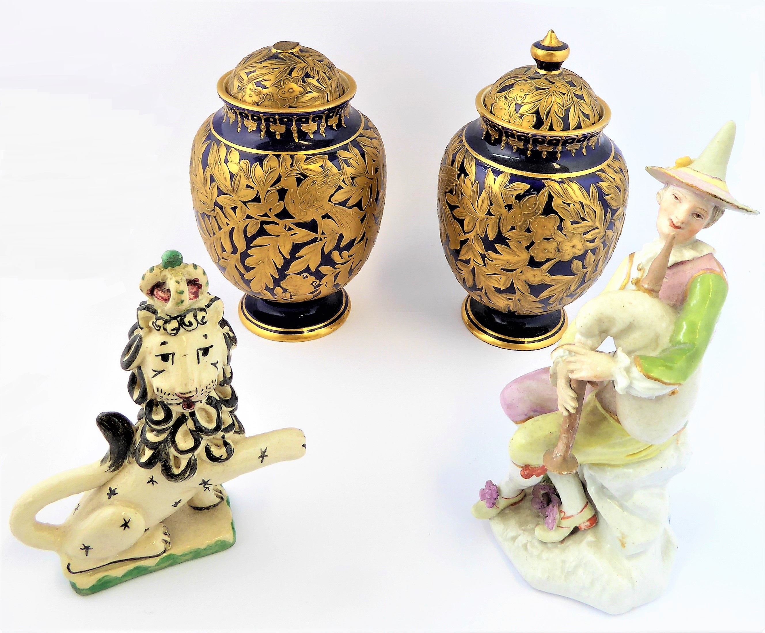 A  group of four: 1. a 19th century Meissen-style porcelain figure of a harlequin playing the