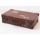 A vintage pre-war brown leather suitcase with brass lock fittings, the lid with stencilled