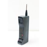 A retro Motorola 8500X early mobile phone, with charging dock and mains adaptor, rubber perishing to