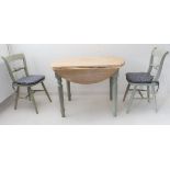 A modern drop-leaf circular top kitchen table in 19th century style and with with two matching