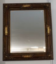 A gilt-framed wall-hanging looking glass in 19th century style and with hand-bevelled plate, a