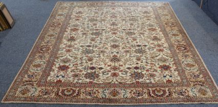 A Persian Tabriz carpet; all-over ivory ground with stylised flowers surrounded by one main ivory