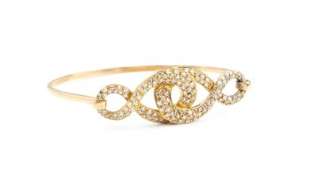 An 18ct yellow gold and diamond bangle - unmarked, tests as 18ct, the open, interlaced scrollwork