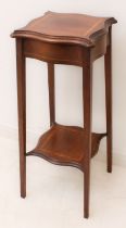 An Edwardian satinwood-banded mahogany serpentine lamp table - the moulded top raised on square