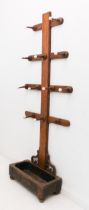 A Victorian honey oak hall stand or coat rack: with pottery capped pegs, on a trough base for
