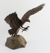 A bronze figure of an eagle in flight - late 20th century, with wings and talons outstretched as
