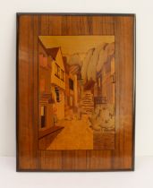 An early 20th century specimen-wood marquetry panel depicting a continental-style village scene with