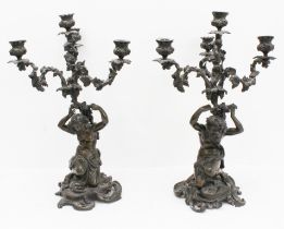 A large and heavy pair of 19th century patinated bronze four-light candelabra: in High Rococo style;