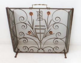 An Arts and Crafts style wrought-iron and wire-mesh folding fire screen: barleytwist brass handle;