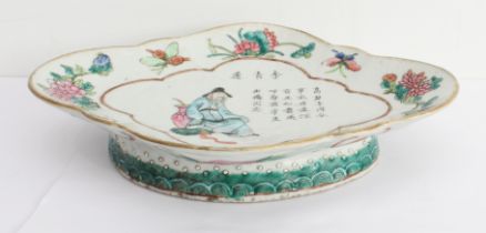 A 19th century Chinese lozenge-shaped pedestal dish decorated in enamels: seated male figure dressed