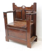 An early 20th century Arts & Crafts style oak monk's style seat: the two panelled back flanked by
