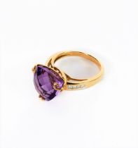 A 9-carat yellow gold dress ring: centrally set with a trillion-cut amethyst of good colour, unusual