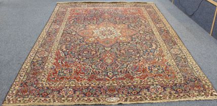 A Persian Tabriz carpet; large red and ivory central floral medallion surrounded by scrolls of