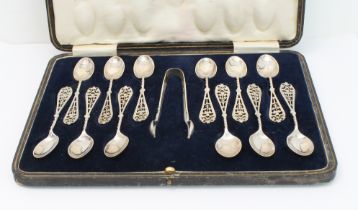 A cased set of twelve George V silver coffee spoons and sugar tongs: pierced terminals with