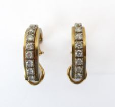 A pair of 14ct two-colour gold and diamond half hoop earrings - each set with a row of nine