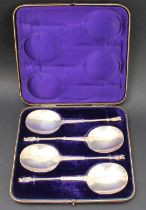 A cased set of four hallmarked silver serving spoons; each with engraved scrollwork-style decoration