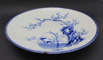 A large late 19th century Japanese porcelain charger: hand-decorated in underglaze blue with blue