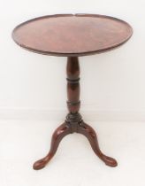 A George III period circular-topped mahogany occasional table: the dished mahogany top above a