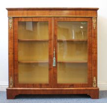 A walnut pier cabinet with moulded top, boxwood-strung frieze with central marquetry motif, two