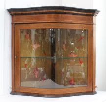 An Edwardian inlaid mahogany serpentine glazed corner cabinet