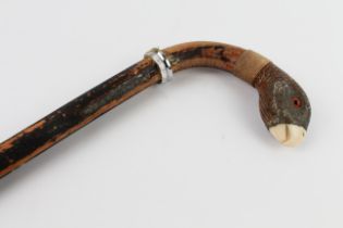 An ebonised walking cane (probably early 20th century): the curved handle with a white metal mounted