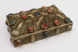 A white metal gilded box with overall filigree decoration and set with numerous cabochon stones,