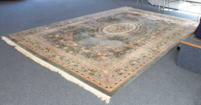 A Chinese carpet with a teal ground, ivory central medallion surrounded by vases of flowers, one