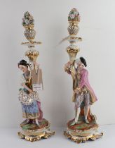 A pair of 19th century hand gilded and decorated continental porcelain candlesticks of figural form: