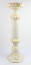 A modern carved sectional alabaster pedestal stand: circular top carved with stylised leaves above a