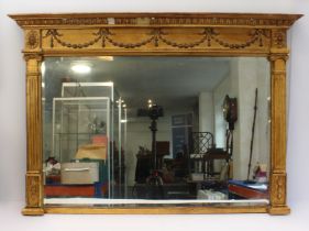 A 19th century gilt-framed overmantle mirror in late 18th century style: bows, swags and husks to