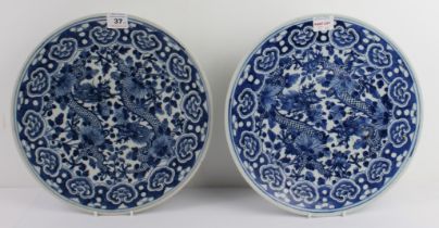 A pair of Chinese blue-and-white porcelain chargers: probably late 19th century, painted with two