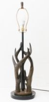 A modern faux antler table-lamp: the three 'antlers' mounted on a stepped bronzed and black