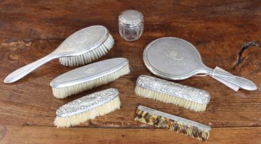 Silver-mounted dressing table wares to include: a set of hand-held mirror, clothes brush and hair