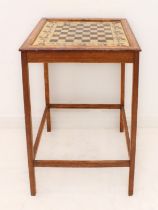 An early 20th century oak occasional table with gilded and painted glass chequerboard top: the 64