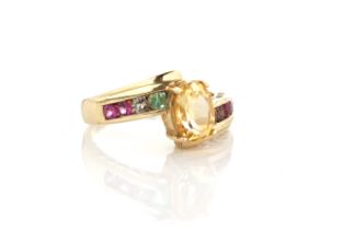 A 10ct yellow gold, citrine and multi-gem ring - the central oval cut citrine in a cross-over