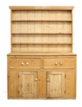 A 19th century pine dresser: the shelved superstructure (with later boards) above two half-width