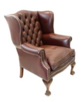 A large and comfortable brown leather buttonback upholstered wing-backed armchair in  18th century