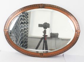 An Arts and Crafts copper-framed oval mirror with bevelled plate (68 x 48 cm.).