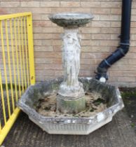 A composite stone garden fountain or water feature - the large, octagonal base with central square