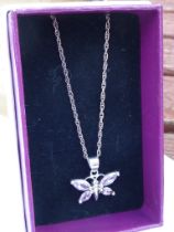A boxed silver pendant modelled as a butterfly with hand-cut pink stones upon a silver chain.