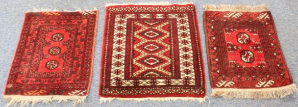 Three small red ground Bokhara-style rugs (the largest 69.5 x 64 cm).