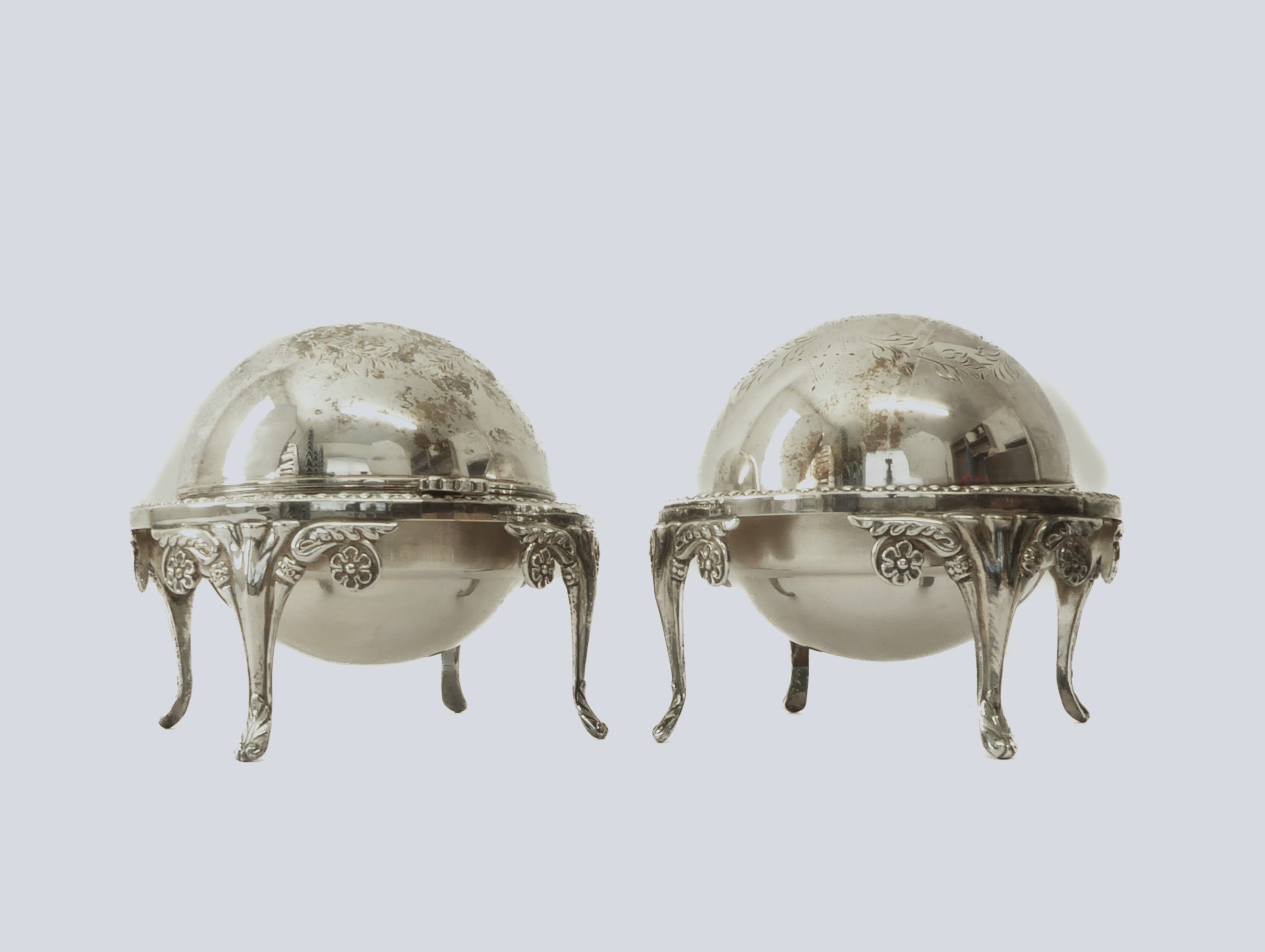 A pair of silver-plated butter dishes - 1930s-40s, with hinged domed covers chased with foliate