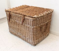 A large early 20th century wicker trunk with leather securing straps and two rope handles (LWH 96