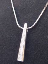 An obelisk-shaped silver pendant mounted with graduated hand-cut white stones, upon a silver