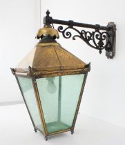 A large late 19th century style brassed lantern of square tapering form: the black painted scrolling