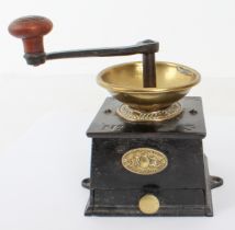 A late 19th/early 20th century cast iron and brass-mounted coffee grinder: with turned wooden knop